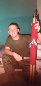 Joe Rasmussen in a military uniform holding a red unit flag, or guidon.