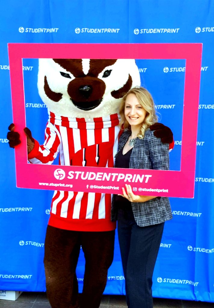 Jolene Anders posing with Bucky Badger and holding a frame that says "StudentPrint."