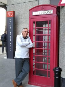 Stephan Gregar standing in front of a red telephone booth.