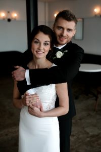 Kari Patterson, the bride, poses for a photo with the groom on her wedding wedding day in an empty room.