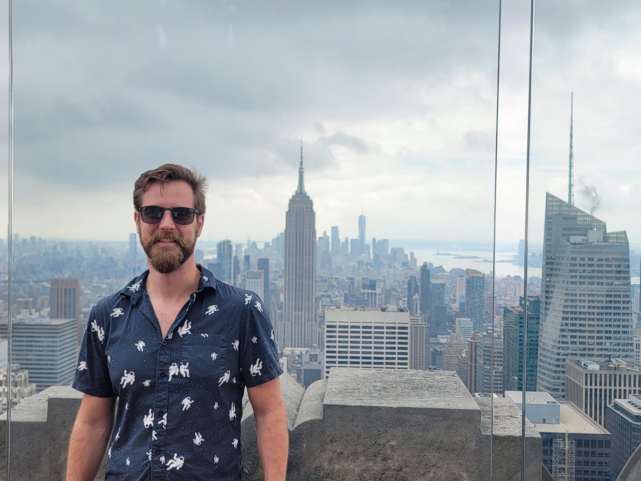 Dustin Lewis posing with the empire state building behind him.
