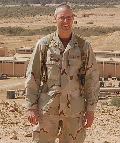 Pete Boll in his Navy uniform on a military base in the desert.