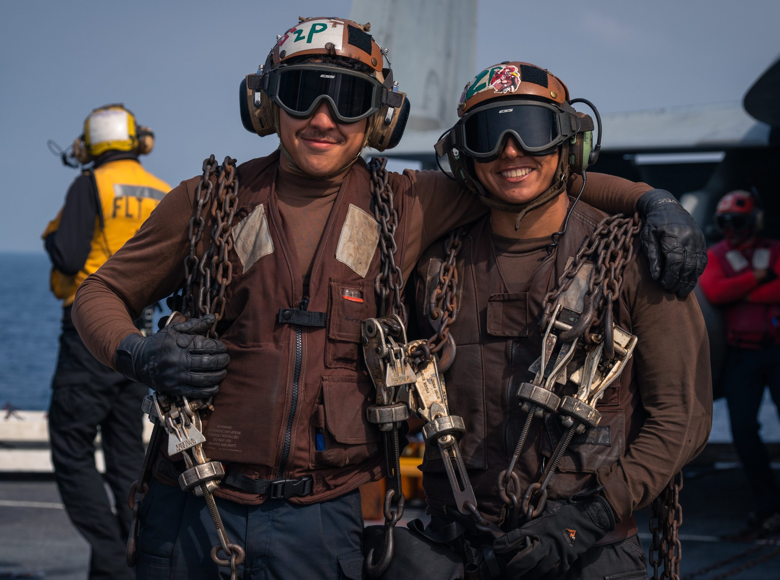 Frank Torres in uniform with another soldier outside by a body of water.