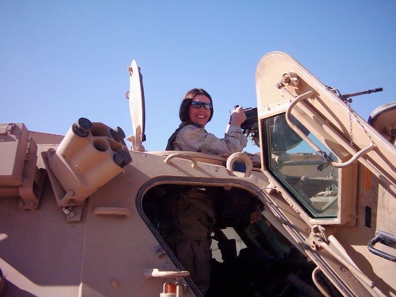Elizabeth Parizo in uniform in an armored vehicle smiling for a photo.