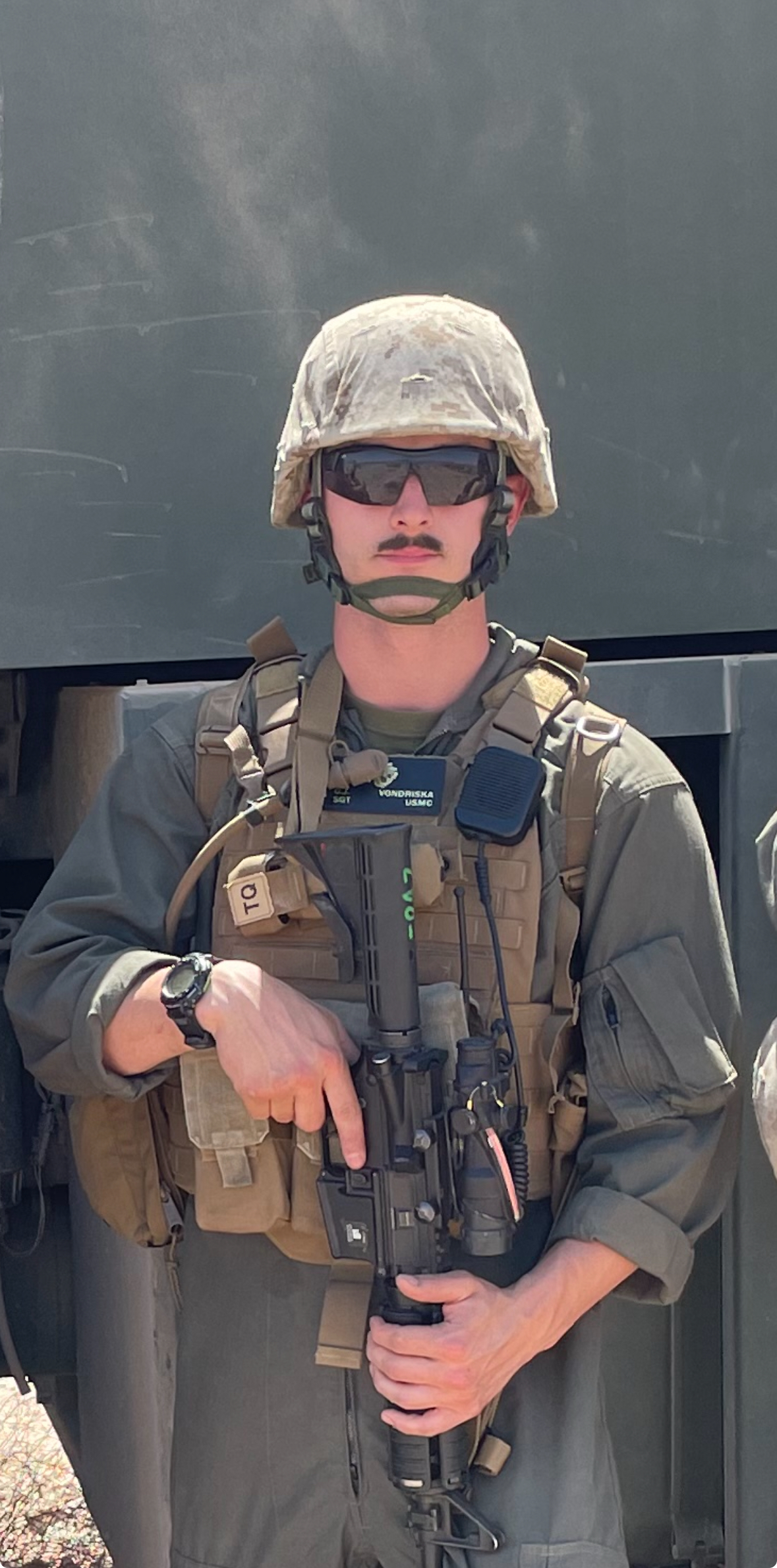 George Vondriska in uniform holding a rifle as he poses for a picture.