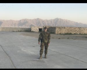 Eliza Rushlow in uniform smiling for a photo with mountains in the background.