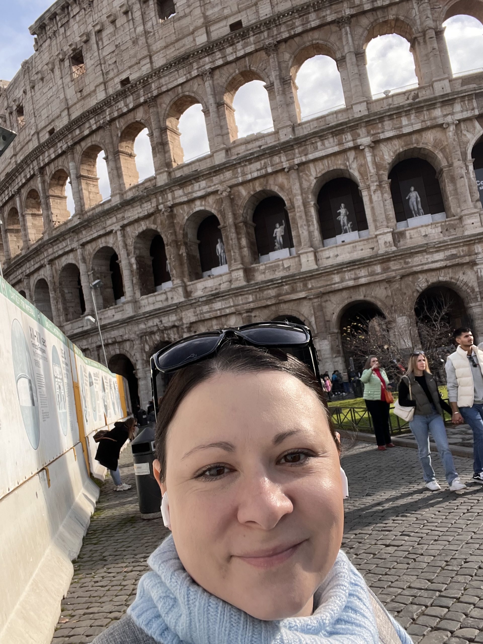 Amber Kirkpatrick taking a selfie with the coliseum behind her.