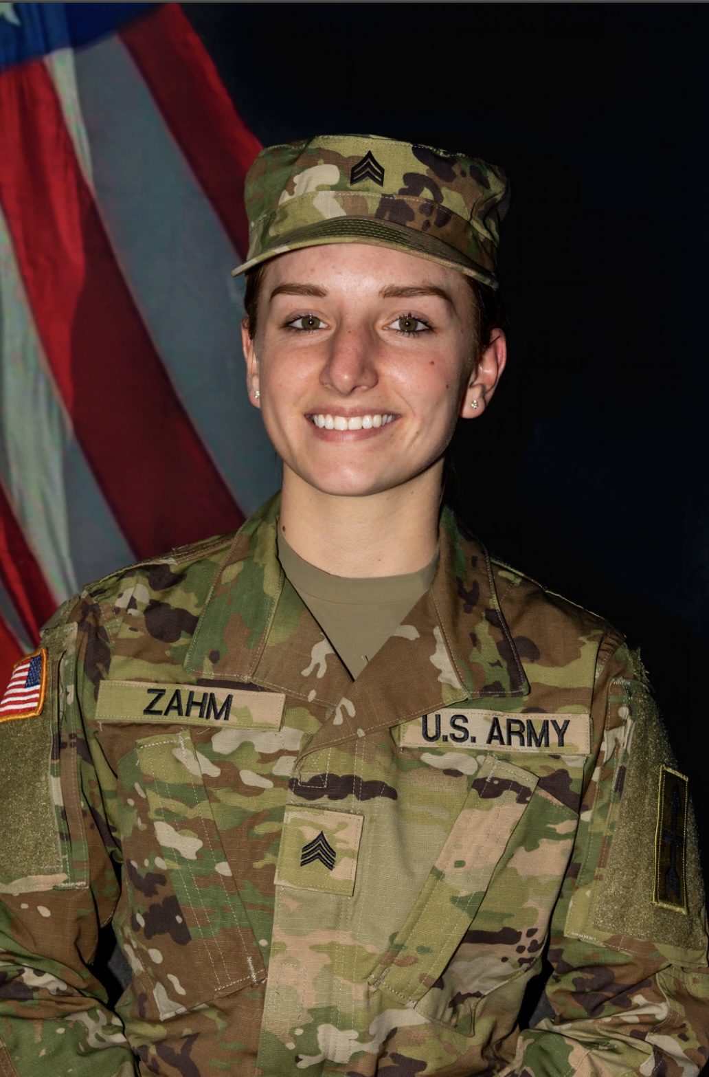 Ruthie Zahm in uniform sitting in front of a U.S. flag smiling for a photo.