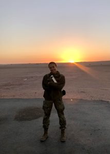 Mira Tcherneva in uniform posing for a photo with a sunset in the background.