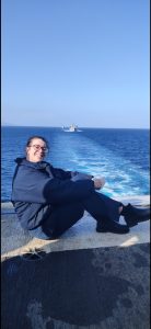Cheyenne Mackai sitting and smiling for a photo with a body of water in the background.