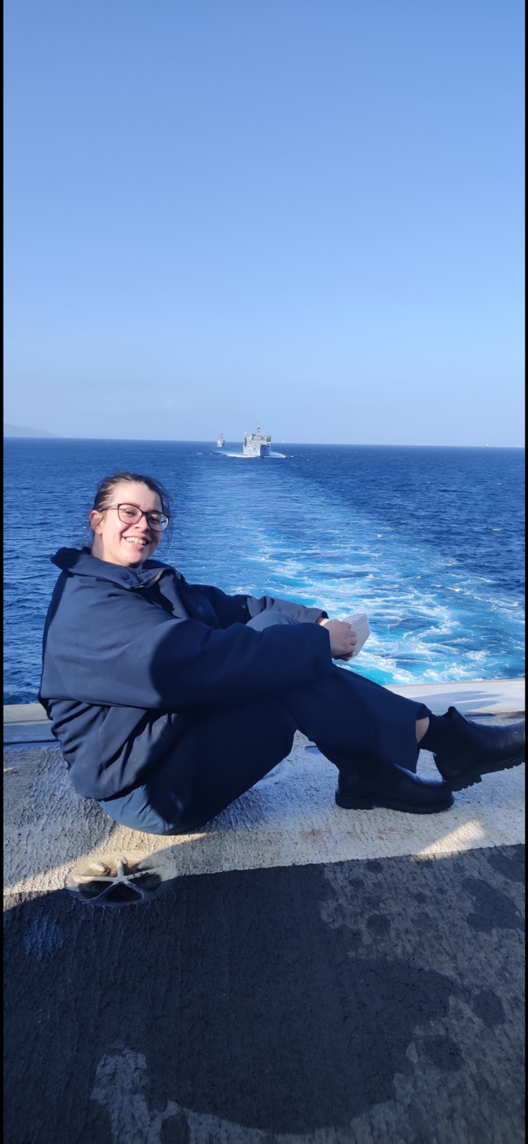 Cheyenne Mackai sitting and smiling for a photo with a body of water in the background.