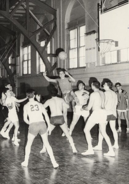 A group of men playing basketball in the Red Gym.